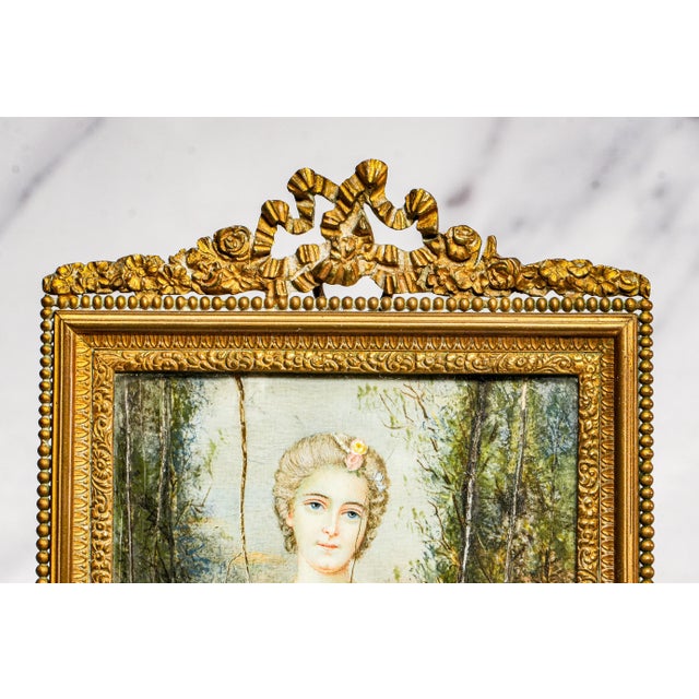 A refined and evocative glimpse into the elegance of a bygone era, this antique portrait miniature painting captures the...