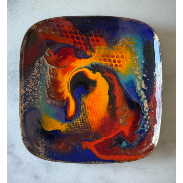 Vintage copper enamel square plate with vibrant swirls of gold, purple, orange, red, and turquoise with a black enamel...