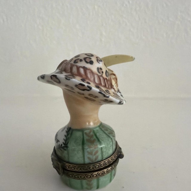 The Lovely Limoges Trinket Box Chapeaux De Paris Vert is a charming and elegant collectible item featuring a green color...