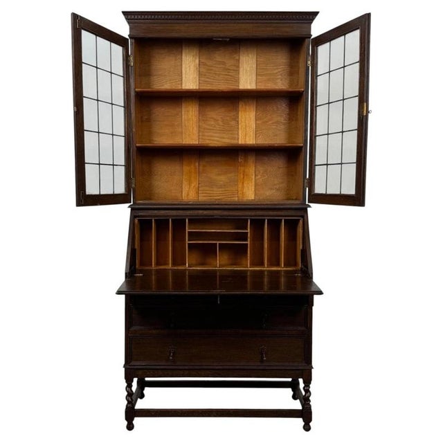A handsome and substantial 20th-century Jacobean style bureau bookcase, beautifully crafted in oak and combining glazed...