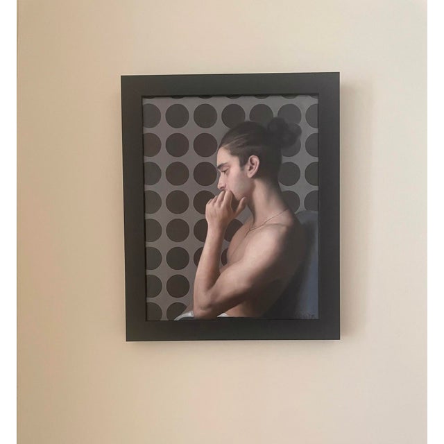 The artwork features a contemplative figure, captured in profile with a thoughtful expression, emphasizing a moment of...