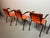 Set of four Mid-Century dining chairs designed by Arend de Cirkel. The chairs feature fresh orange leatherette upholstery...