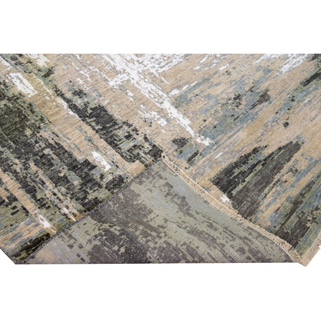 Beautiful modern Indian hand-knotted wool and silk rug with a beige field. This modern rug has gray, brown, ivory, and...