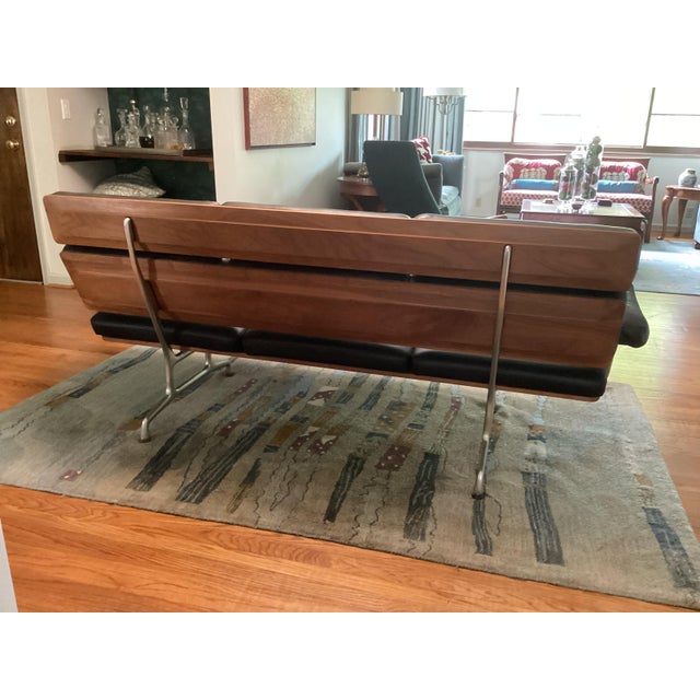 Original 1984 Charles and Ray Eames 3 seat sofa. Walnut, gunstock oil finish and black leather. Aluminum polished legs and...