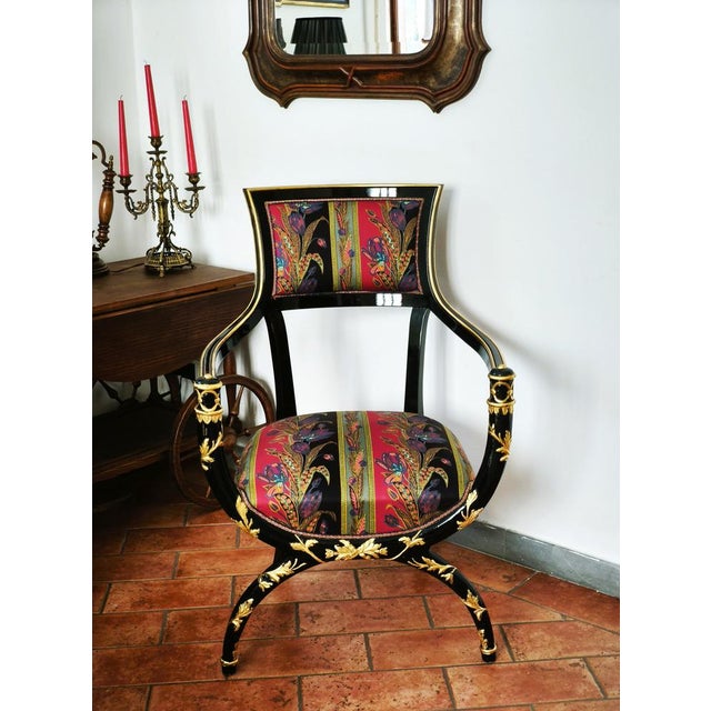 A striking Italian armchair combining neoclassical influences with bold decorative character. The chair features a black...
