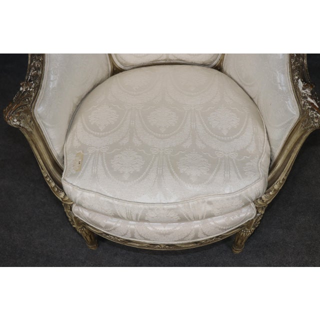 This elegant French Louis XV bergère chair, finished in a soft crème painted surface, carries with it the honest passage...