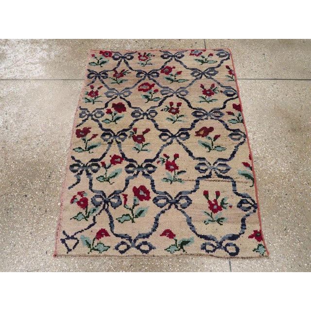 This mid-20th century Turkish Anatolian rug, measuring 2' 10" x 3' 10", presents a charming floral lattice design infused...