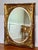 Large Italian baroque giltwood and paint decorated oval beveled mirror in a rectangular frame, Italy, circa 1920....