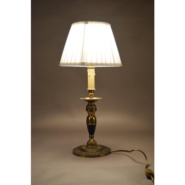 A refined vintage brass table lamp with an elegant candlestick silhouette, finished with a deep green accent and a crisp...