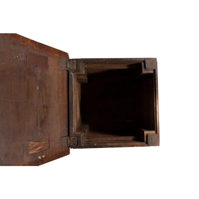 Almost square hinged top opening to a compartment. The front with two false drawers. Bun feet.