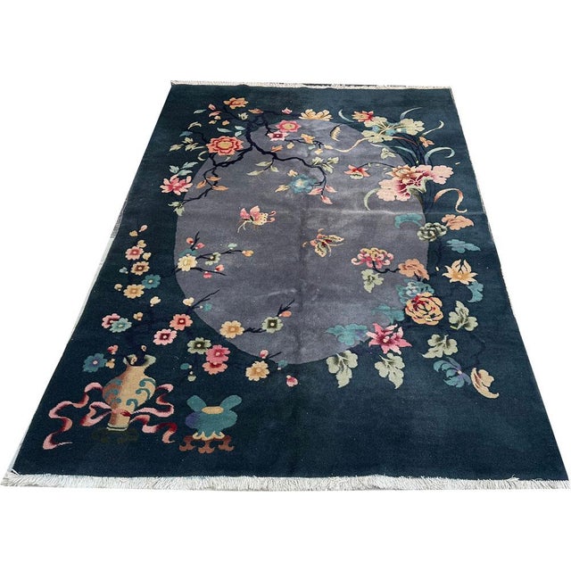This vintage 5'-6" x 8'-5" Art Deco Chinese rug is a stunning piece with a rectangular shape and midnight blue towards...