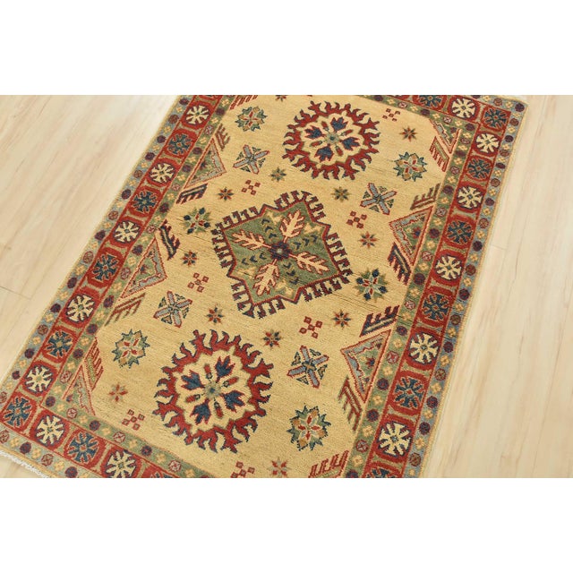 A tribal Caucasian Kazak rug hand-knotted with an all-wool pile on a cotton foundation. This oriental rug features a...