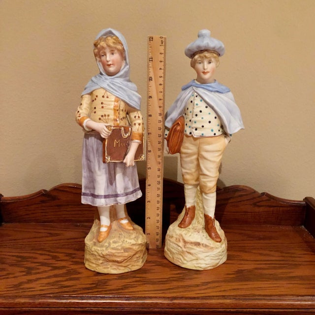 This pair of German bisque figurines of schoolchildren is in good condition as pictured. The girl has a small hole on her...