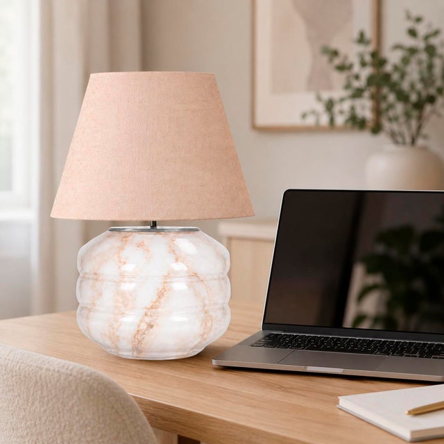Crafted with high visual clarity, this modern table lamp features a sleek silhouette with a hand-blown glass base paired...