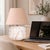 Crafted with high visual clarity, this modern table lamp features a sleek silhouette with a hand-blown glass base paired...