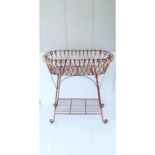 A French iron garden plant pot holder stand jardiniere, circa early-20th century, France. This sculptural flower or plant...