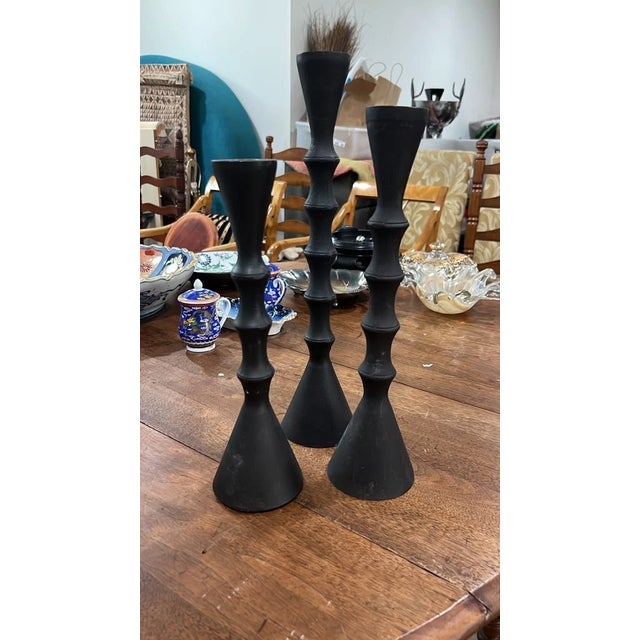 Add a bold, modern touch to your space with this set of three graduated metal candlesticks. Featuring a sleek matte black...