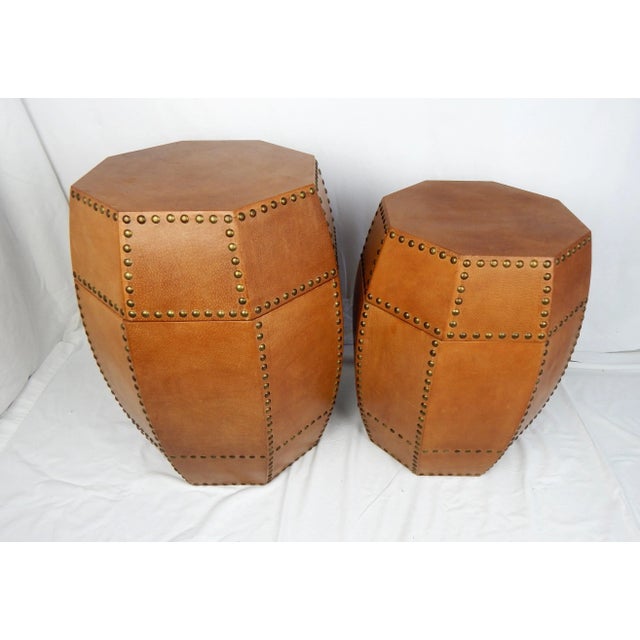 A pair chic complimentary sized faux leather octagonal table storage containers featuring decorative bronze tacks on...