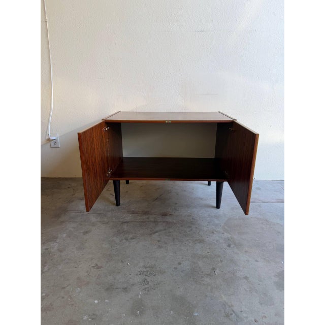 This vintage Danish cabinet is a refined example of classic Mid-Century Modern Scandinavian design. Crafted in richly...