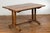 A rustic farmhouse table from the 19th century with trestle base and custom distressed finish. Emanating timeless charm...