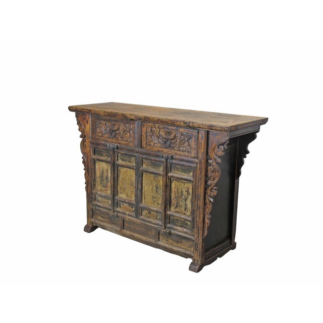 This antique elm sideboard features 2 upper drawers detailed with deep, hand-carved floral and leaf motifs and circular...