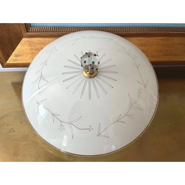 Elegant modern frosted glass flush mount ceiling light with central transparent sunburst topped by a blue polka dotted...