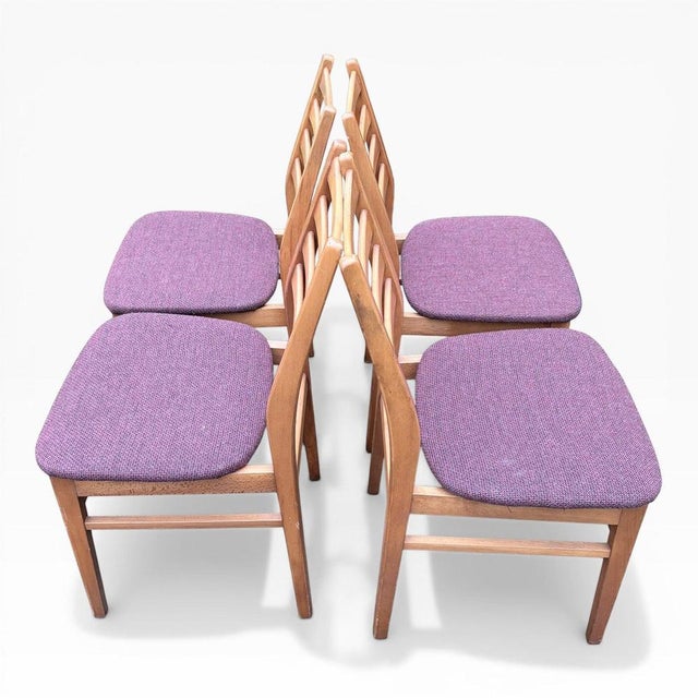 A stylish set of four mid-century teak ladder back dining chairs, showcasing classic Scandinavian-inspired design from the...