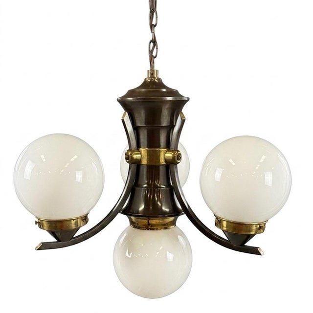 An elegant Art Deco chandelier defined by its balanced composition and gently curved arms carrying spherical opaline glass...