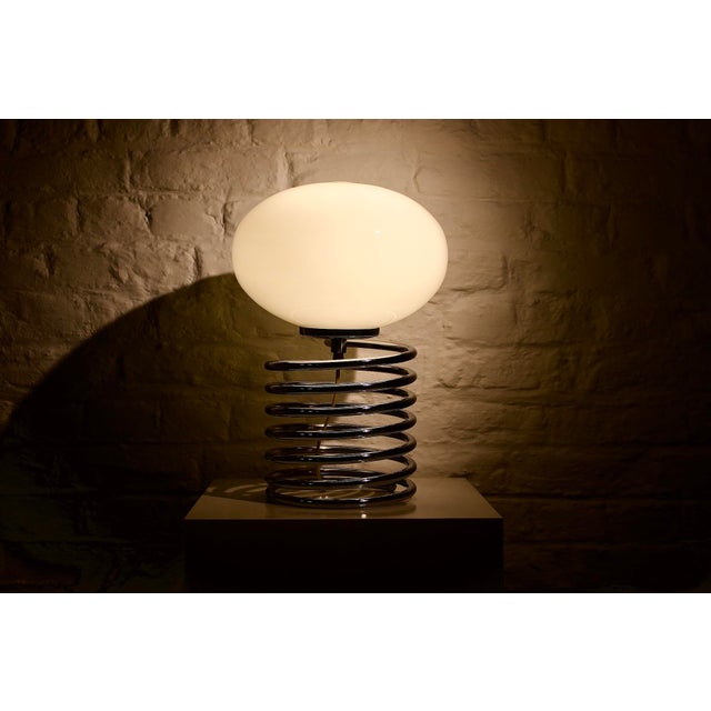 Large-format "Spring" model, characterized by a chromed steel base and an elongated opal glass shade with soft lines....