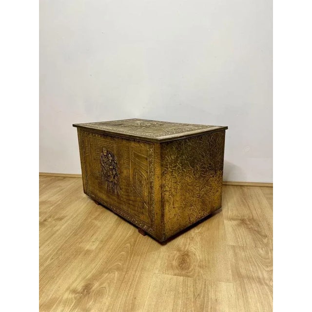 Antique quality ornate brass coal box having a quality ornate brass lift up lid with figures, foliage and trees opening to...