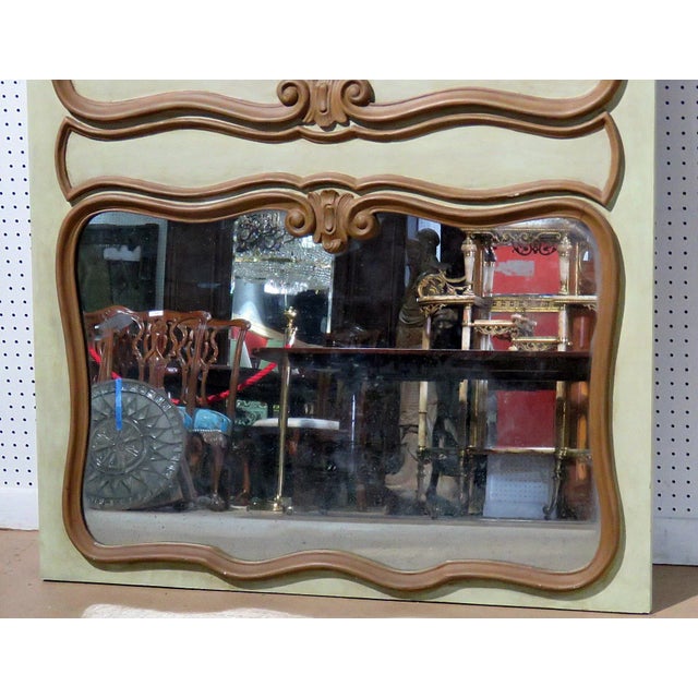 This carved French crème painted trumeau mirror beautifully embodies the elegance and artistry of 18th-century French...