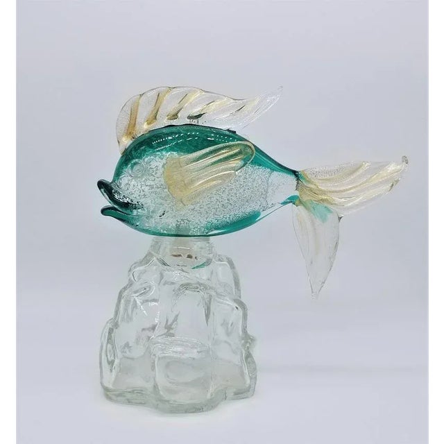 Offered for sale is a Archimede Seguso for Girolamo Luxardo Murano glass fish standing on a transparent glass bottle in...