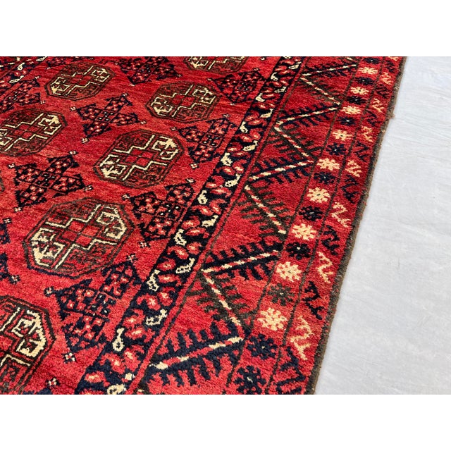 A vintage Afghan Ersari Turkmen rug in the classic Bokhara design — three columns of quartered octagonal güls march in...