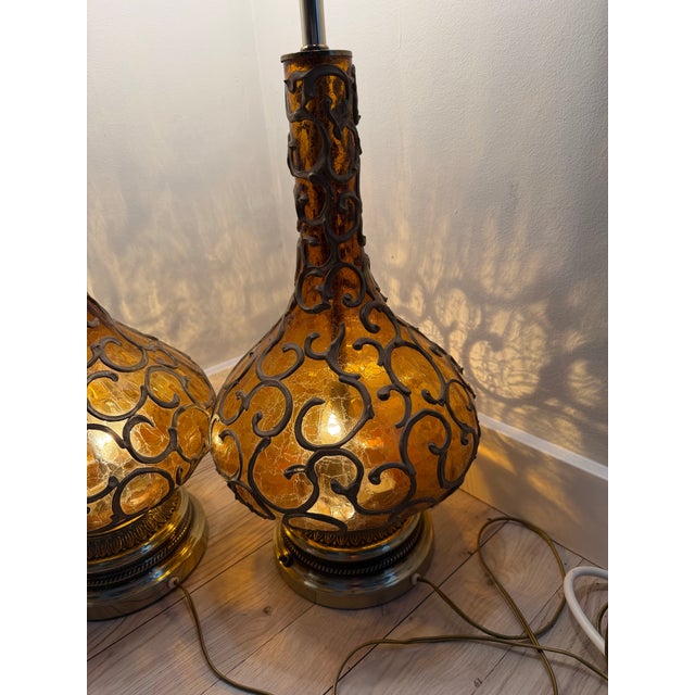 Capture the ultimate mid-century ambiance with this striking, rare pair of 1960s amber "genie bottle" table lamps. These...