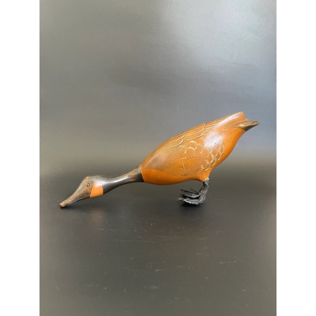 A vintage wood Canada Goose in drinking position. Hand carved and hand painted with nice details. Glass eyes, metal feet....
