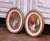 This elegant pair of antique wall pendants was crafted in France circa 1960 and features hand-painted genre scenes...