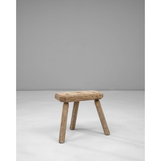 This 20th Century French oak tripod stool showcases a beautifully simple, rustic form shaped by practical craftsmanship....
