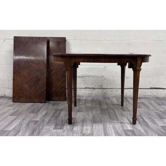 This is an elegant vintage Drexel Passage round extension dining table featuring beautifully figured mahogany veneer, a...