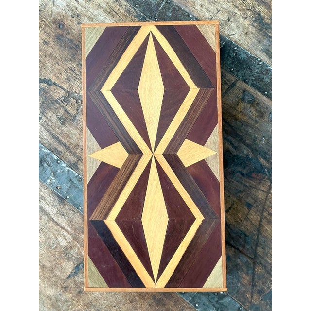 This striking vintage wooden box is a masterwork of complex parquetry, showcasing a meticulously hand-assembled marquetry...