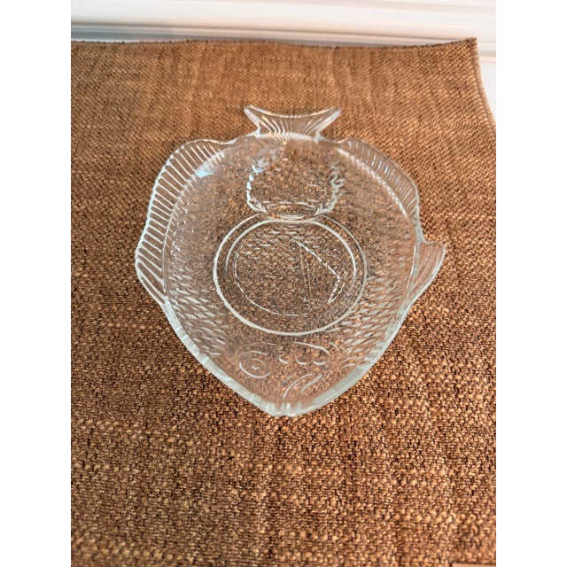 Charming set of seven vintage clear pressed glass fish-form plates featuring beautifully molded scales, fin details, and a...