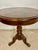 Elegant round occasional table featuring a beautifully inlaid top and sculptural tripod base. The circular top displays...