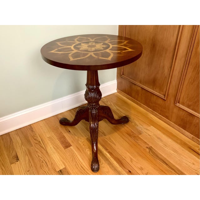 A round mahogany pedestal Maitland Smith side table with an inlaid marquetry radiating satinwood floral pattern, fluted,...