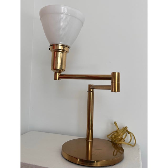 A beautiful Walter Von Nessen swing arm lamp in brushed brass with a milk glass diffuser. A perfect mid-century piece for...