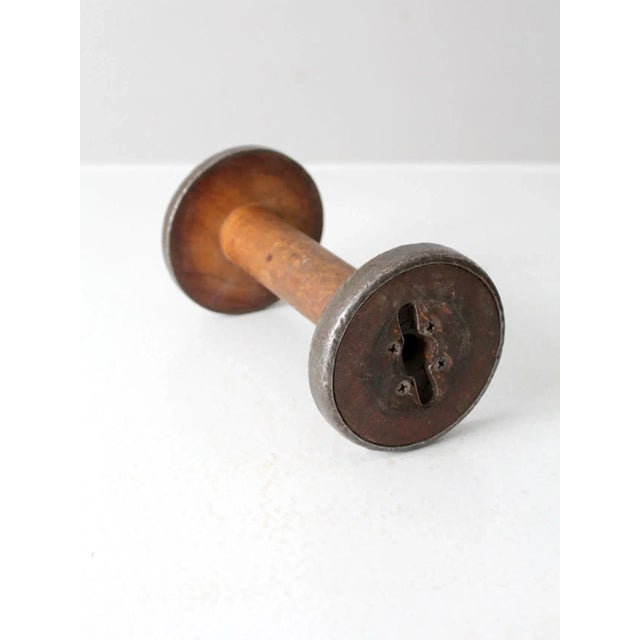 This is an antique wooden spool. With beautiful patina, the large wood spool feature metal hardware and lovely remnants of...