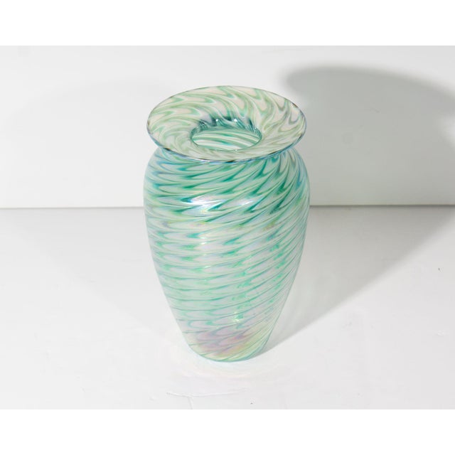 A 1973 art glass vase from Glass Eye Studio. This vase features an classic shape with a blue-green iridescent feather...