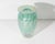A 1973 art glass vase from Glass Eye Studio. This vase features an classic shape with a blue-green iridescent feather...