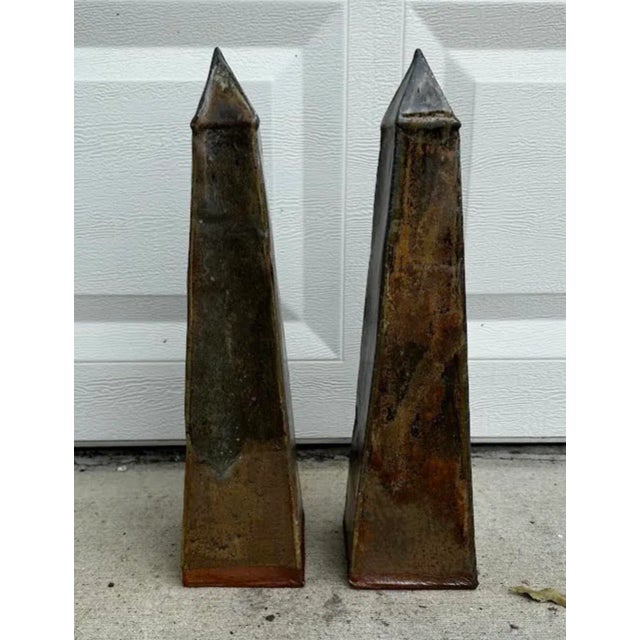 A pair of hand built soda fired ceramic obelisks in a variegated copper and brown glaze.