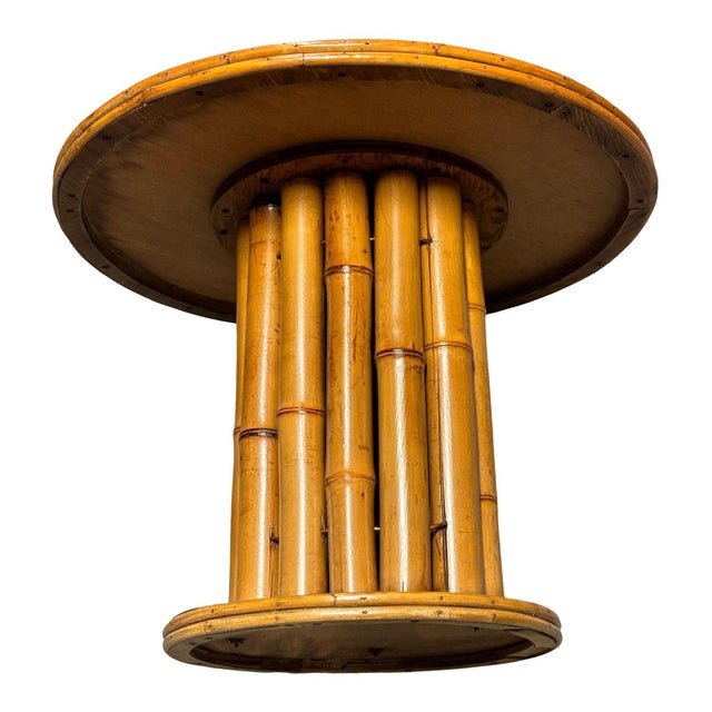 This restored rattan round pedestal end table boasts a charming vertically stacked rattan design featuring vertically...