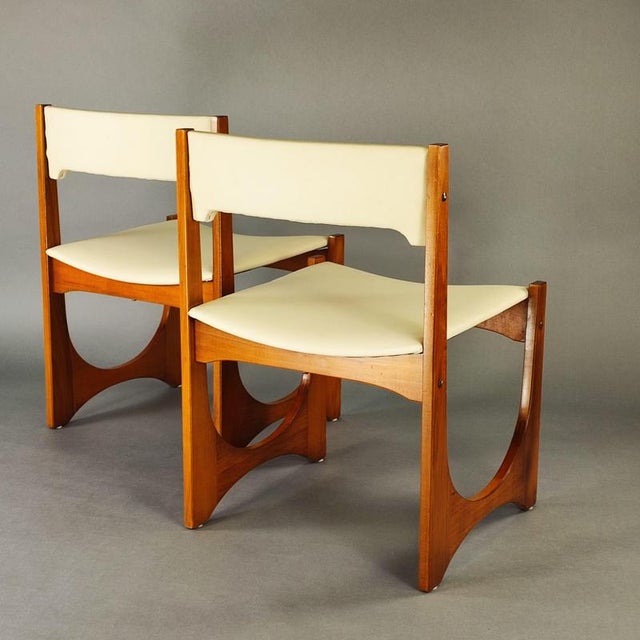 Set of two upholstered chairs with a distinctive 1970s design. Blonde walnut frame with a distinctive U-shape, padded seat...