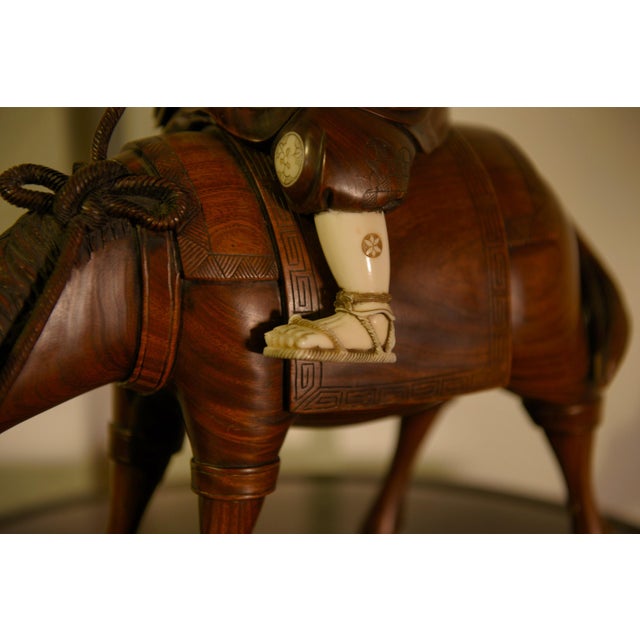 A finely carved East Asian okimono depicting a scholarly horseman. Its style and subject matter likely originate in Japan....